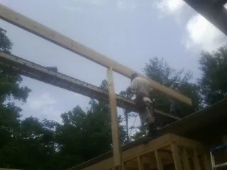 Carpenter setting a ridge beam over a new addition frame — Ice Dam Removal by Roofing Brothers in Lavalette
