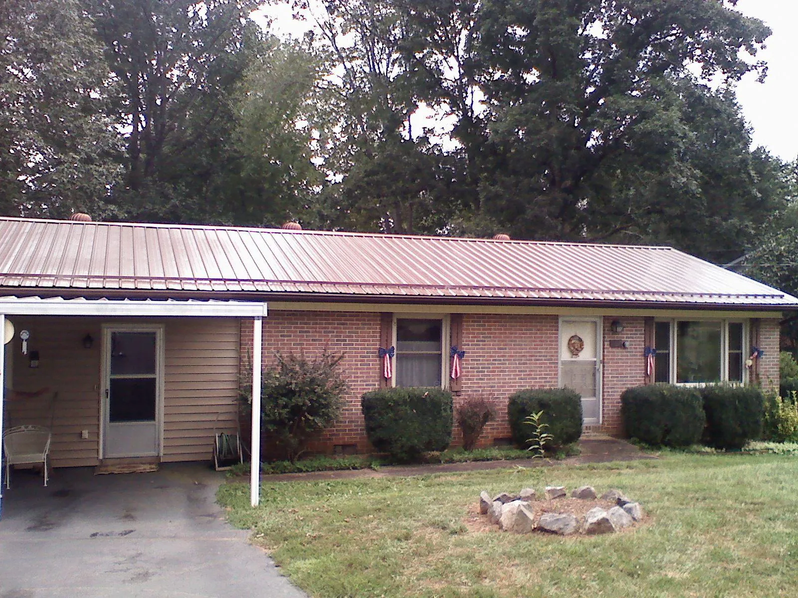 Bronze metal roof and carport on a brick ranch home — Roof Repair work by our crew in Lavalette